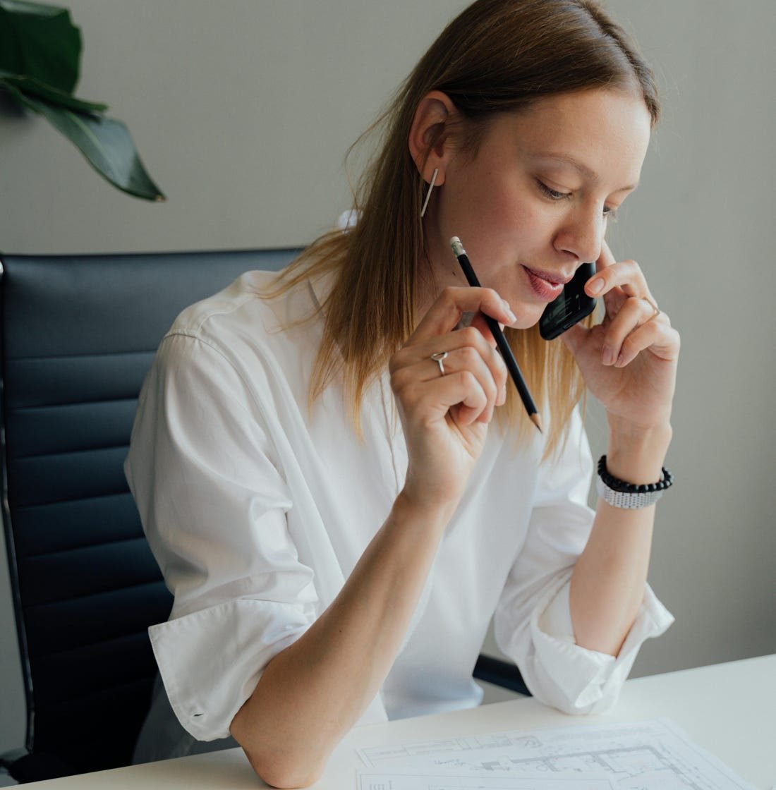 Professional woman discussing architecture planning over the phone.